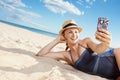 Closeup on happy woman taking selfie with phone on seashore Royalty Free Stock Photo