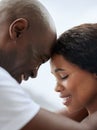 Closeup of a happy young african american couple posing with their foreheads together. Black man and woman smiling and