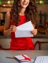 Closeup on happy housewife with christmas letter in kitchen Royalty Free Stock Photo