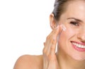 Closeup on happy young woman applying creme Royalty Free Stock Photo