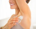 Closeup on happy young woman applying deodorant Royalty Free Stock Photo