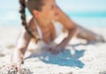 Closeup on happy young woman laying on beach