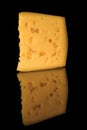 closeup hard porous yellow cheese piece with holes