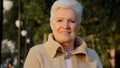 Closeup head shot portrait middle aged senior retired woman standing posing outdoors, enjoying weekend lazy time in park Royalty Free Stock Photo