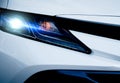 Closeup headlamp light of a white luxury car. Automotive industry concept. Electric car or hybrid vehicle concept. Automobile Royalty Free Stock Photo