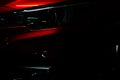 Closeup headlight of shiny red luxury SUV compact car. Elegant electric car technology and business concept. Hybrid auto Royalty Free Stock Photo