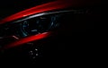 Closeup headlight of shiny red luxury SUV compact car. Elegant electric car technology and business concept. Hybrid auto Royalty Free Stock Photo