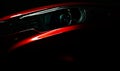 Closeup headlight of shiny red luxury SUV compact car. Elegant electric car technology and business concept. Hybrid auto Royalty Free Stock Photo