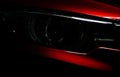 Closeup headlight of shiny red luxury SUV compact car. Elegant electric car technology and business concept. Royalty Free Stock Photo