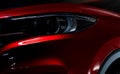 Closeup headlight of shiny red luxury SUV compact car. Elegant electric car technology and business concept. Hybrid auto Royalty Free Stock Photo