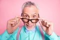 Closeup headshot photo of shocked surprised grandfather taking off eyeglasses smiling isolated on pink color background