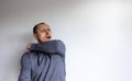 Closeup headshot portrait petrified young handsome man in a grey wear sneezes on the elbow, isolated on beautiful white background Royalty Free Stock Photo