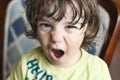 Closeup headshot portrait of a young white Caucasian boy throwing a temper tantrum, looking directly at the camera Royalty Free Stock Photo