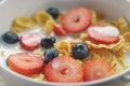 Closeup of healthy breakfast with corn flakes and berries in white bowl Royalty Free Stock Photo