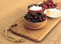 Closeup of healthy breakfast: cottage cheese, strawberries, cherry and sliced cheese on wooden board. Retro styled photo. Royalty Free Stock Photo