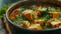 A closeup of a hearty bowl of algaebased soup filled with chunks of vegetables tofu and a rich broth made from algae