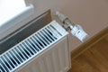 Closeup of heating radiator valve for comfortable temperature regulation on metal radiator on inrerior wall Royalty Free Stock Photo