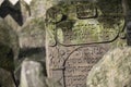 Closeup of Hebrew engravings on an old stone in a graveyard under the sunlight
