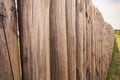 Closeup high old wooden fence of logs in form of palisade Royalty Free Stock Photo