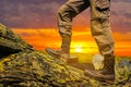 Closeup hiker mount slope ascending on dramatic sunset background Royalty Free Stock Photo