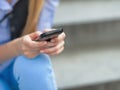 Closeup on hipster girl writing sms while sitting on stairs