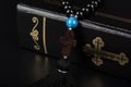 Closeup of Holy Bible and rosary beads with cross on black background. Religion concept and faith Royalty Free Stock Photo