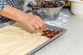 Closeup of a home baker preparing raw batter and dried fruits on a baking pan Royalty Free Stock Photo