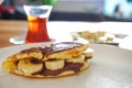 Closeup of homemade pancakes with Nutella hazelnut cream and bananas for breakfast