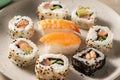 Closeup homemade sushi rolls with salmon, shrimp, avocado i n a round plate Royalty Free Stock Photo