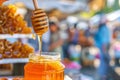 closeup of a honey dipper dripping honey back into the jar at a market stand Royalty Free Stock Photo