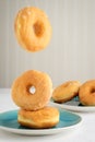 Honey glazed donuts falling on plate Royalty Free Stock Photo