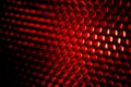 Closeup honeycomb grid texture with red light. Red and dark metal hexagon shaped pattern abstract background. Light modifier