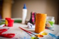 Closeup horizontal shot of yellow cardboard tube on a background of painting materials for children