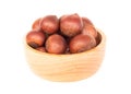 Closeup horse chestnuts in wood bowl isolated on white background, healthy food concept