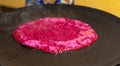 Closeup of hot beetroot pancake on a tawa or a flat pan Royalty Free Stock Photo