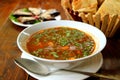 Closeup Hot Georgian Beef Soup Khashi with Blurry Bread and Eggplant Rolls in the Backdrop Royalty Free Stock Photo