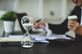 Closeup hourglass on office desk with blurred businessman working on background Royalty Free Stock Photo