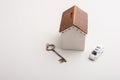 Closeup of a house coin bank next to a car and a key - concept of savings