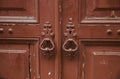 Detail of a house entrance, with door knob and keyhole, flaking brown paint