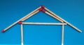 A house of matchsticks over blue background.