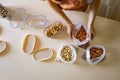 Closeup housewife hands placing nuts plastic package into container box on wooden table at kitchen Royalty Free Stock Photo