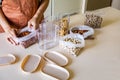 Closeup housewife hands placing nuts plastic package into container box on wooden table at kitchen