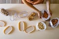 Closeup housewife hands placing nuts plastic package into container box on wooden table at kitchen Royalty Free Stock Photo