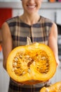 Closeup on housewife in kitchen showing pumpkin Royalty Free Stock Photo