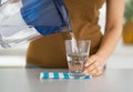 Closeup on housewife pouring water into glass Royalty Free Stock Photo