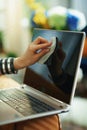 Stylish woman wiping laptop display with cleaning cloth Royalty Free Stock Photo