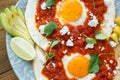 Closeup of huevos rancheros with sliced avocado