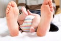 Closeup of huge feet of father and little newborn baby