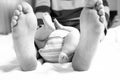 Closeup of huge feet of father and little newborn baby