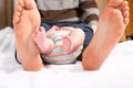 Closeup of huge feet of father and little newborn baby. Big feet of adult and tiny legs of child. Happy parenthood